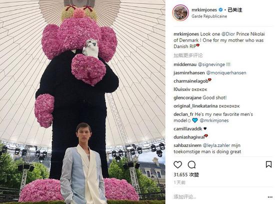 王子在大秀现场巨大的 KAWS 形象玩偶前留影